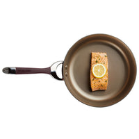 An 11-Piece Cookware Set containing a nonstick, hard-anodized pan effortlessly holds a perfectly cooked salmon topped with a lemon slice.