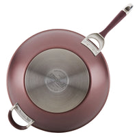Introducing the 14-Inch Nonstick Stir Fry pan in a stylish maroon exterior, designed with a hard-anodized nonstick surface. It features two convenient handles and a branded base, allowing you to enjoy the effortless cooking made possible by its TOTAL Nonstick System.