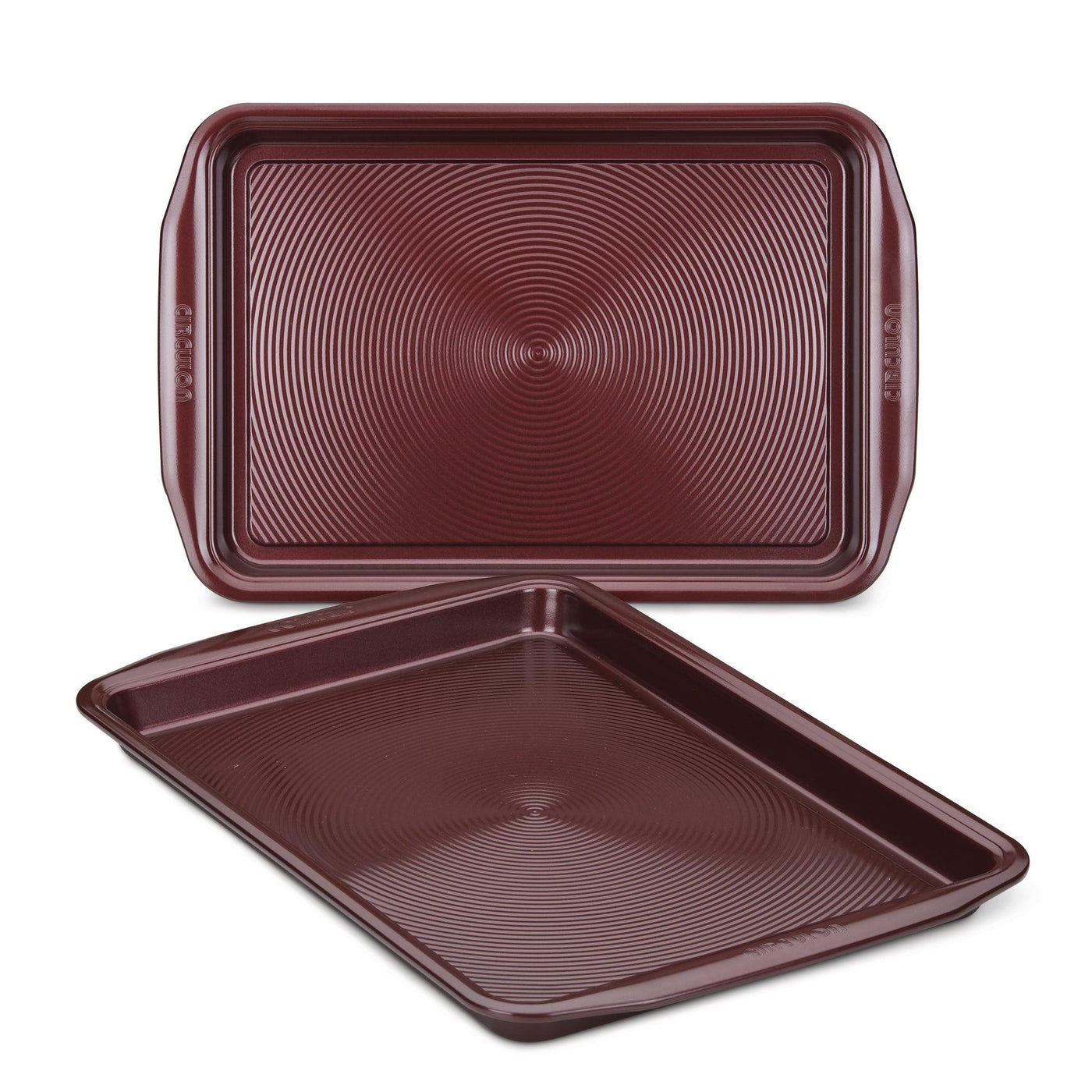 A pair of oven-safe, brown cookie sheets from the 2-Piece Nonstick Cookie Sheet Set, featuring textured surfaces and stacked together, ideal for your culinary creations.